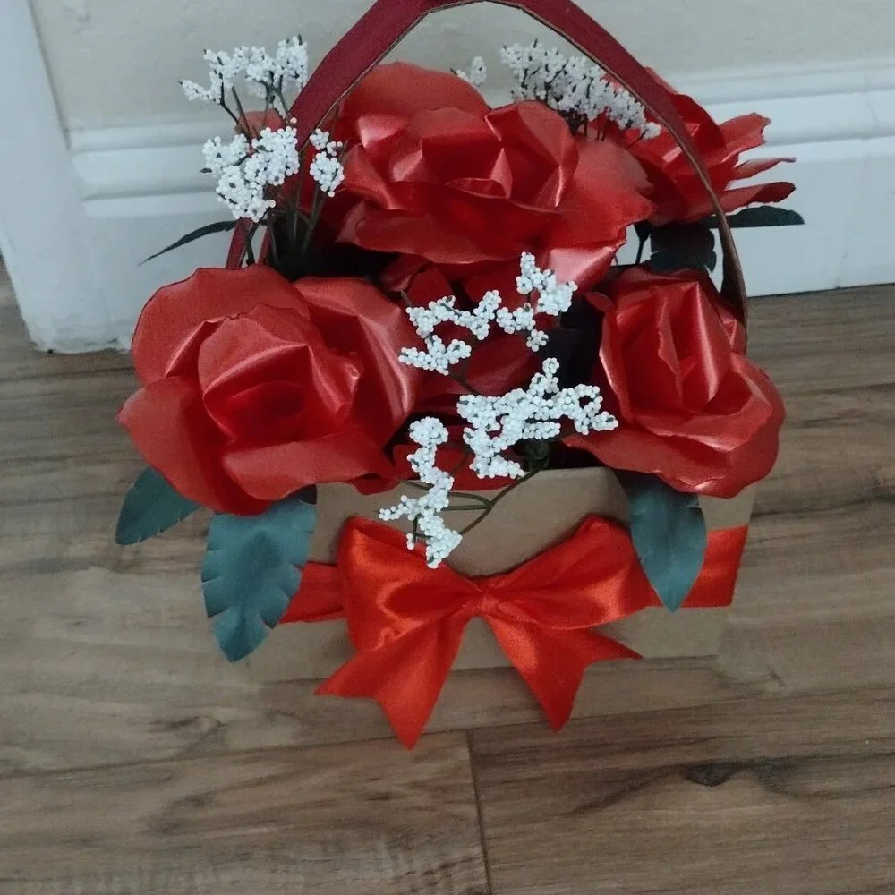 Handmade floral arrangement with plastic ribbon roses.